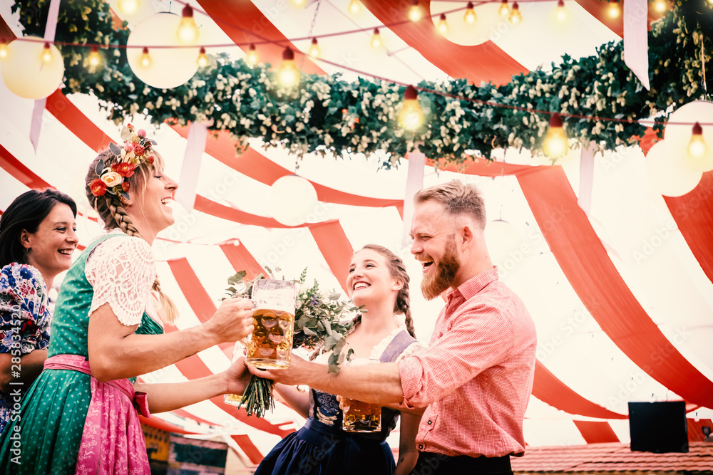 Wall mural Gruppe von Freunden mit Bier auf dem Oktoberfest stoßen an mit Bier im Festzelt