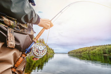 Fisherman spool of rope using rod fly fishing in river