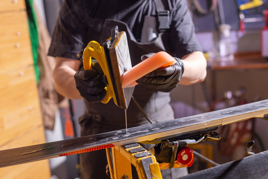 Close Up Of Young Man Repairing The Ski In The Service