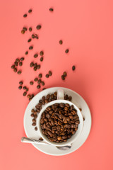 Coffee beans are filled in a white Cup on a pink background.