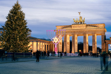 People at Hanukkah Menorah Christmas Tree Brandenburg gate Berlin evening © Roman Babakin