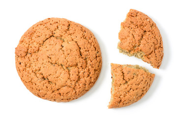 Homemade cookies. Whole and two pieces sweet cookie with crumbs made from oatmeal flour. Tasty biscuit in high resolution closeup, isolated on white background top view with shadows. Homemade bakery.