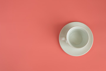 Minimalism white empty Cup with saucer on pink background.