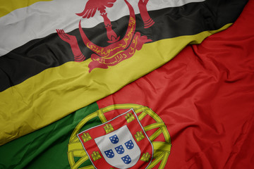 waving colorful flag of portugal and national flag of brunei.