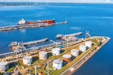 Aerial view large port oil loading terminal with large storage tanks. Railway infrastructure for...
