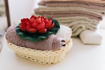 Fototapeta na wymiar Towels arrangement with red orchid flower inside the spa massage centre.