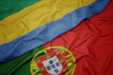 waving colorful flag of portugal and national flag of gabon.