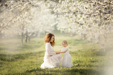 Beautiful mother with her daughter in white dresses.