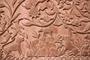 Fototapeta na wymiar Ancient stone bas-relief with flowers and animals in Junagarh fort in Bikaner, Rajasthan, India
