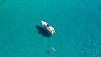 Aerial drone photo of luxury yacht docked in tropical Caribbean bay with turquoise open ocean sea