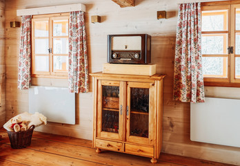 Interior of contemporary living room with dresser and windows