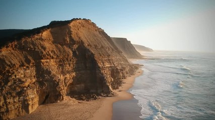 Aerial view of the Sao Juliao beach in Sintra, Portugal. Beach of Atlantic ocean with high cliffs of coastline. Drone view