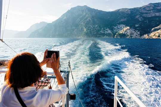 Tourist taking photos during cruise in Tyrrhenian Sea in Positano