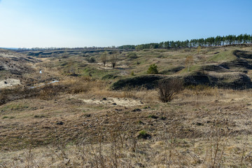 Beautiful spring landscape: trees, forest, mountains, hills, fields, meadows and blue sky.
