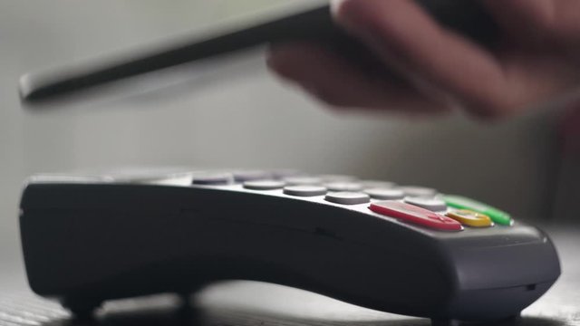 Man hand close up is making transaction using phone pay service, apple pay or google pay system. Making payment terminal mobile app