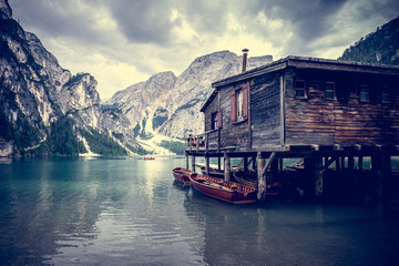 Une cabane en bois avec des barques sur un lac entouré de montagnes