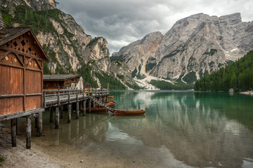 un lac vert au milieu des montagnes, avec des barques et un ponton