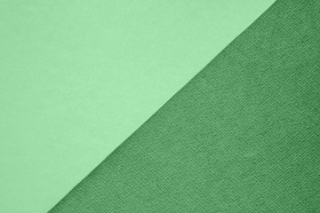 Fototapeta na wymiar Textured and plain paper sheets divided diagonaliy creating line partition. Trendy neo mint and green abstract duo tone background design. Place for text. Top view