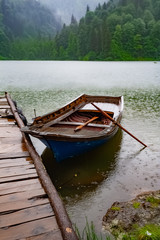Obraz premium Small fishing boat parked in pond at rainy weather