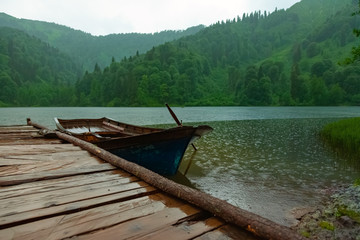 Obraz premium Small fishing boat parked in pond at rainy weather