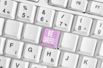 Word writing text Be Careful. Business photo showcasing making sure of avoiding potential danger mishap or harm White pc keyboard with empty note paper above white background key copy space