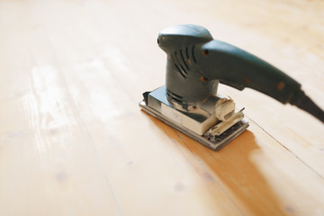 Fototapeta na wymiar wooden floor sanding with flat sander tool