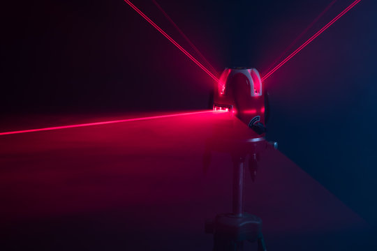 laser level tool red light beams, abstract background