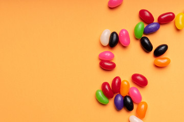 colourful jelly beans candies orange background Top view