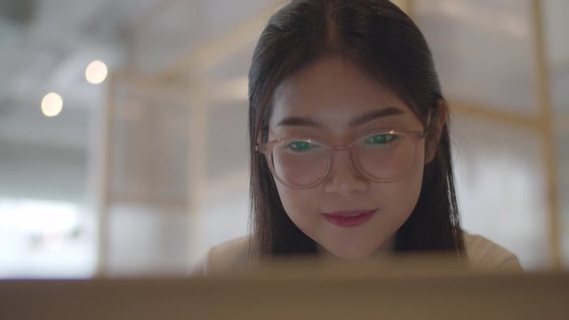 Freelance Asian women working on laptop at office. Young Asia business Girl using the computer for trade, send email, digital work on the internet on table at workplace concept. Slow motion.