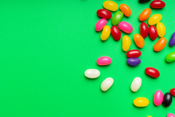 Obraz premium colourful jelly beans candies green background Top view