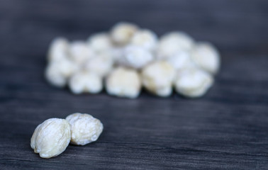 Candlenut or aleurites moluccana on wood background.