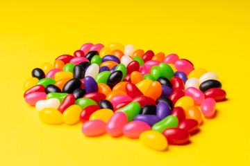 colourful jelly beans candies yellow background Top view 