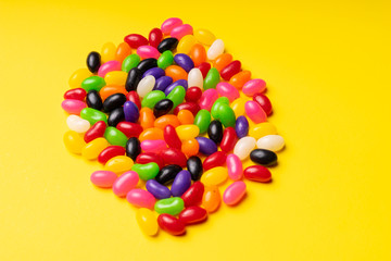 colourful jelly beans candies yellow background Top view 