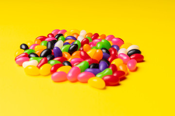 colourful jelly beans candies yellow background Top view 