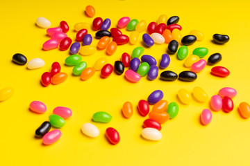 colourful jelly beans candies yellow background Top view 