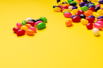 Obraz premium colourful jelly beans candies yellow background Top view 