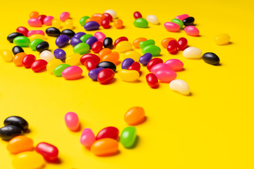 Obraz premium colourful jelly beans candies yellow background Top view 