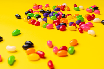 colourful jelly beans candies yellow background Top view 