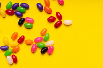 colourful jelly beans candies yellow background Top view 