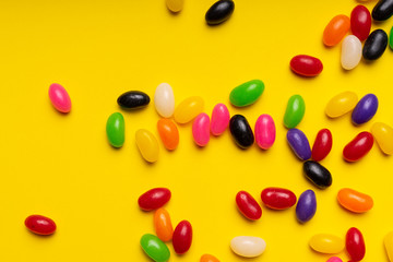 colourful jelly beans candies yellow background Top view 