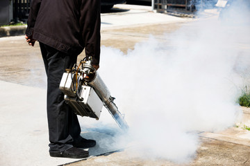 Man pointing smoke machine into manhole for pest control