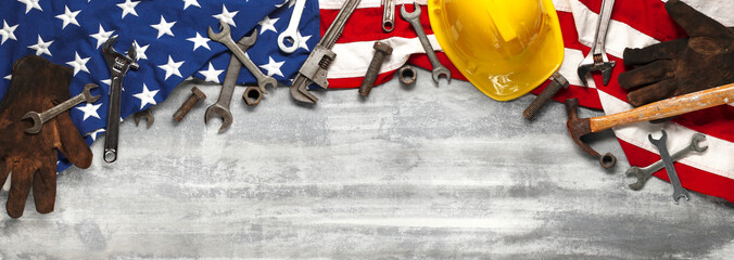 Labor day or American labor concept with construction and manufacturing tools on patriotic US, USA, American flag on white wooden background