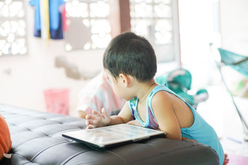 Asian boy playing tablet computer connet to internet browser