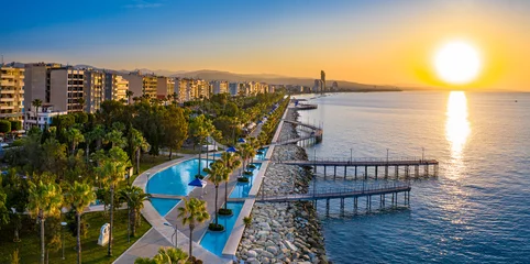 Selbstklebende Fototapete Zypern Republik Zypern. Limassol. Sonnenaufgang über dem Mittelmeer. Die Strandpromenade von Limassol. Wandergebiet mit Meerblick. Am frühen Morgen in Zypern. Die Sonne geht über dem Meer auf. Promenade.