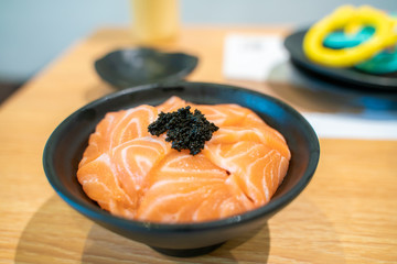 Salmon sashimi on top of japanese rice with fish egg