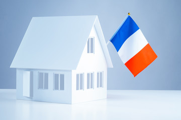 Layout of the house with the flag of France. Buy timeshare in Paris. Buying property in France. Accommodation in Paris. Immigration abroad. Moving to France. Buying a house in Paris.