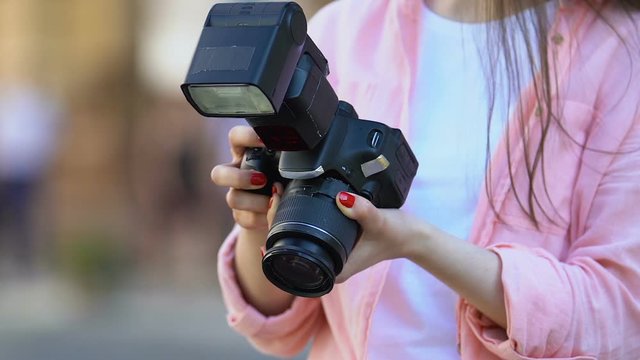 Professional photojournalist choosing pictures holding camera, mass media job
