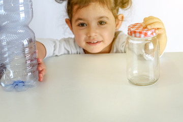 Child pushing the plastic bottle, holding glass jar. No to Plastic Containers, Yes to Glass Jars. Conceptual image for anti plastic campaign.Selective focus.