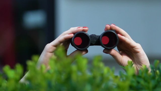 Woman hands holding binoculars, detective investigation, wife spying on husband