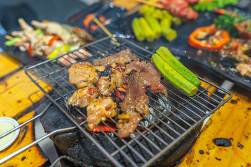 Grilled meat and okra vegetables on charcoal stove with smoke